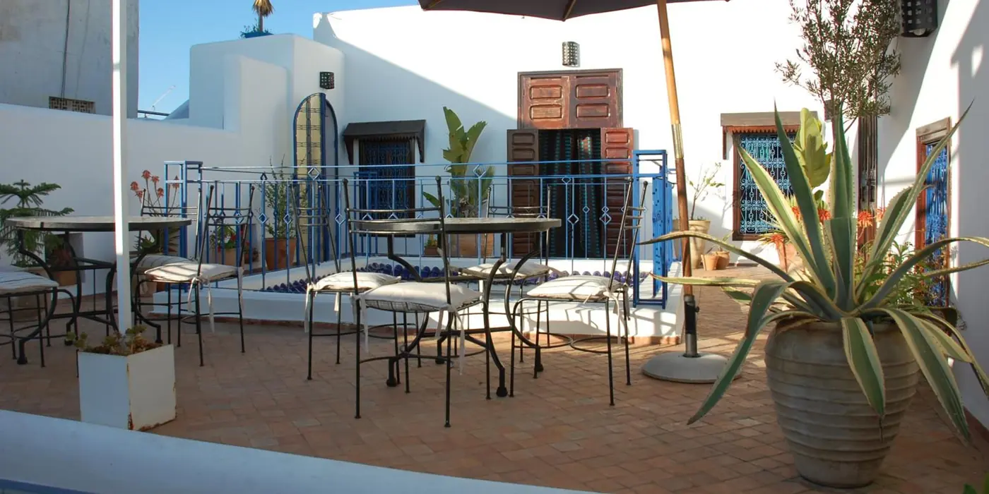 La terrasse, ses tables et le parasol