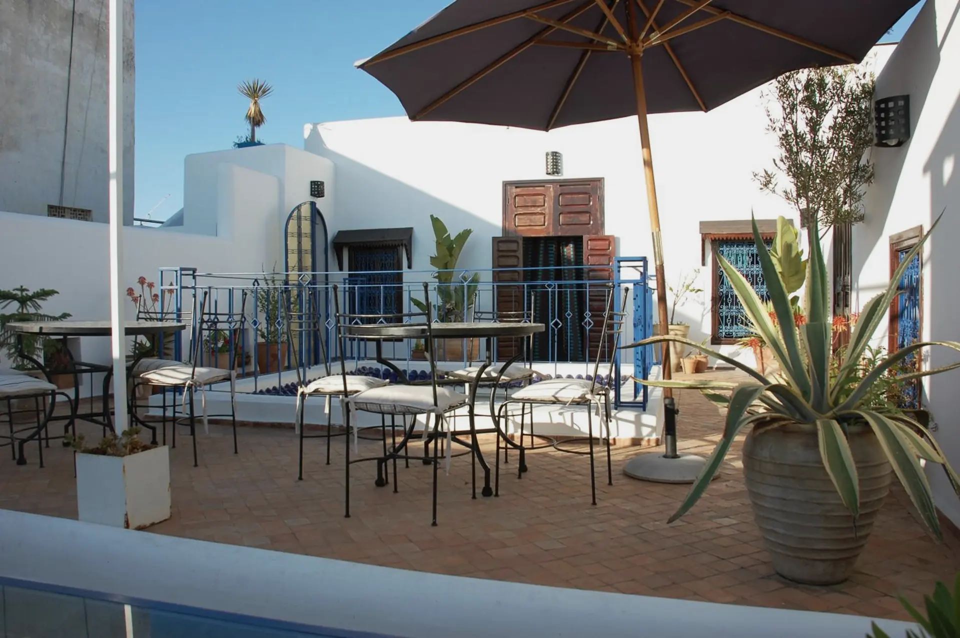 La terrasse, ses tables et le parasol